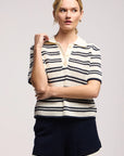 Model wearing the lumae milk and navy stripe short sleeve polo top with shorts on a white background, front