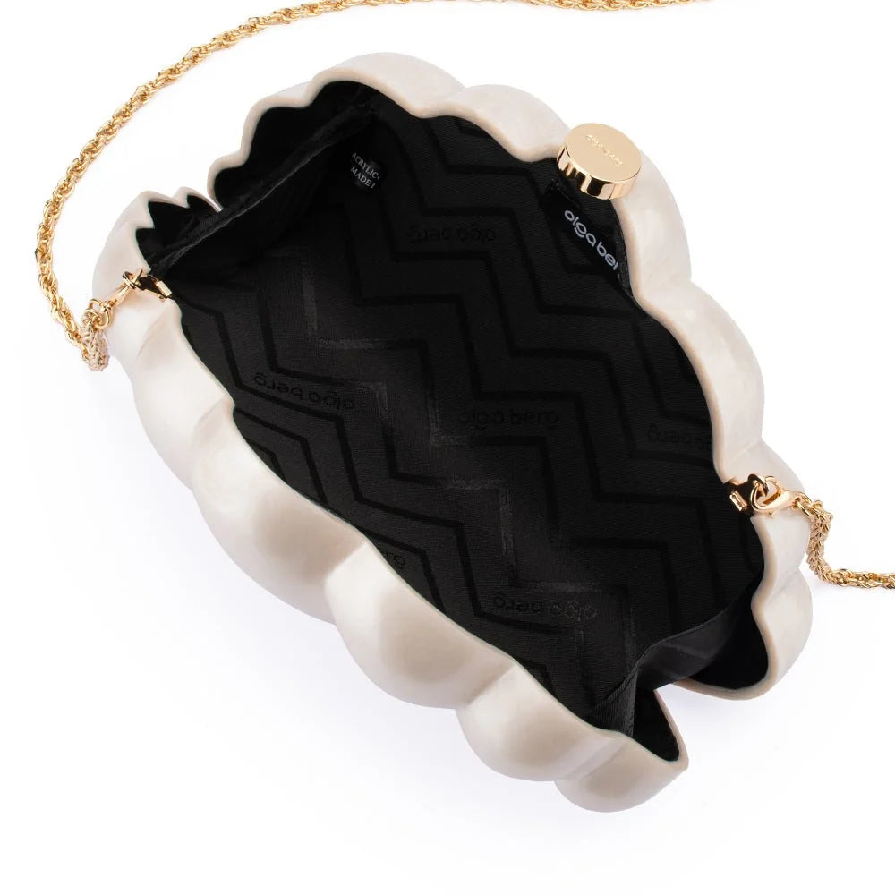 A scalloped cream faux-leather clutch bag with a black chevron-patterned interior lining and a gold chain strap, shown on a white background.