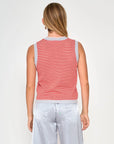 A woman shown from the back wearing a sleeveless red and white striped knit top with light gray trim, paired with light gray pants, against a plain light gray studio background.