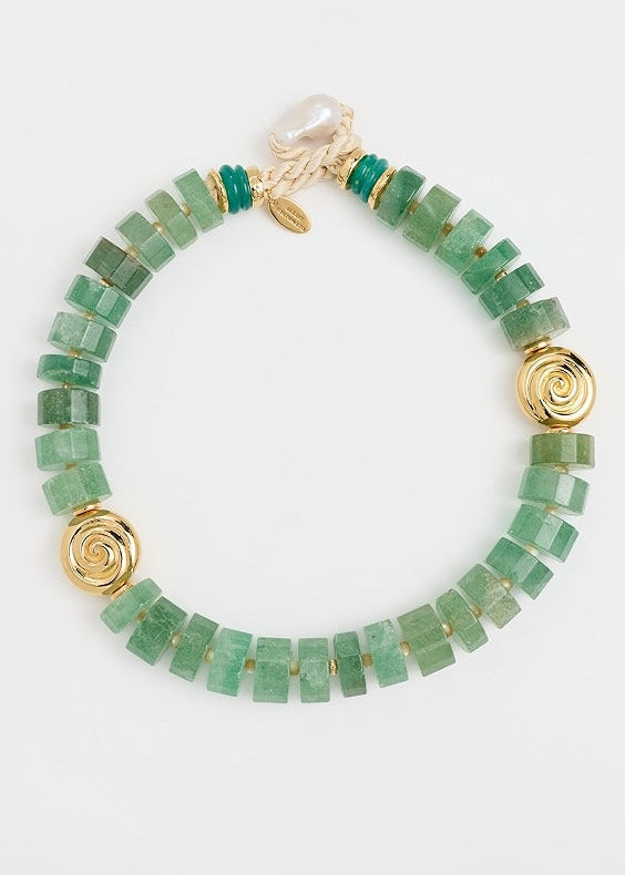 Green beaded bracelet with gold accents on a white background