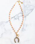 Necklace with a horseshoe charm on a marble surface