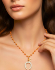 Necklace with a horseshoe pendant worn by a model