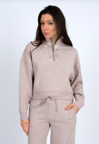Woman wearing a beige tracksuit on a white background front view