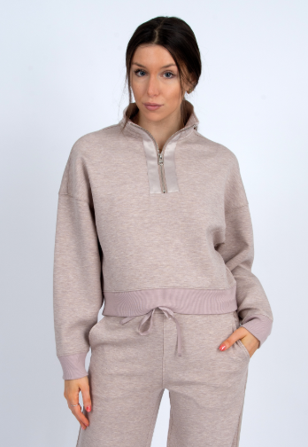 Woman wearing a beige tracksuit on a white background front view