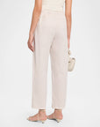 A model shown from the back wearing light beige wide-leg cropped trousers with a small white gingham pattern, paired with beige strappy sandals and holding a matching beige handbag against a plain white studio background.