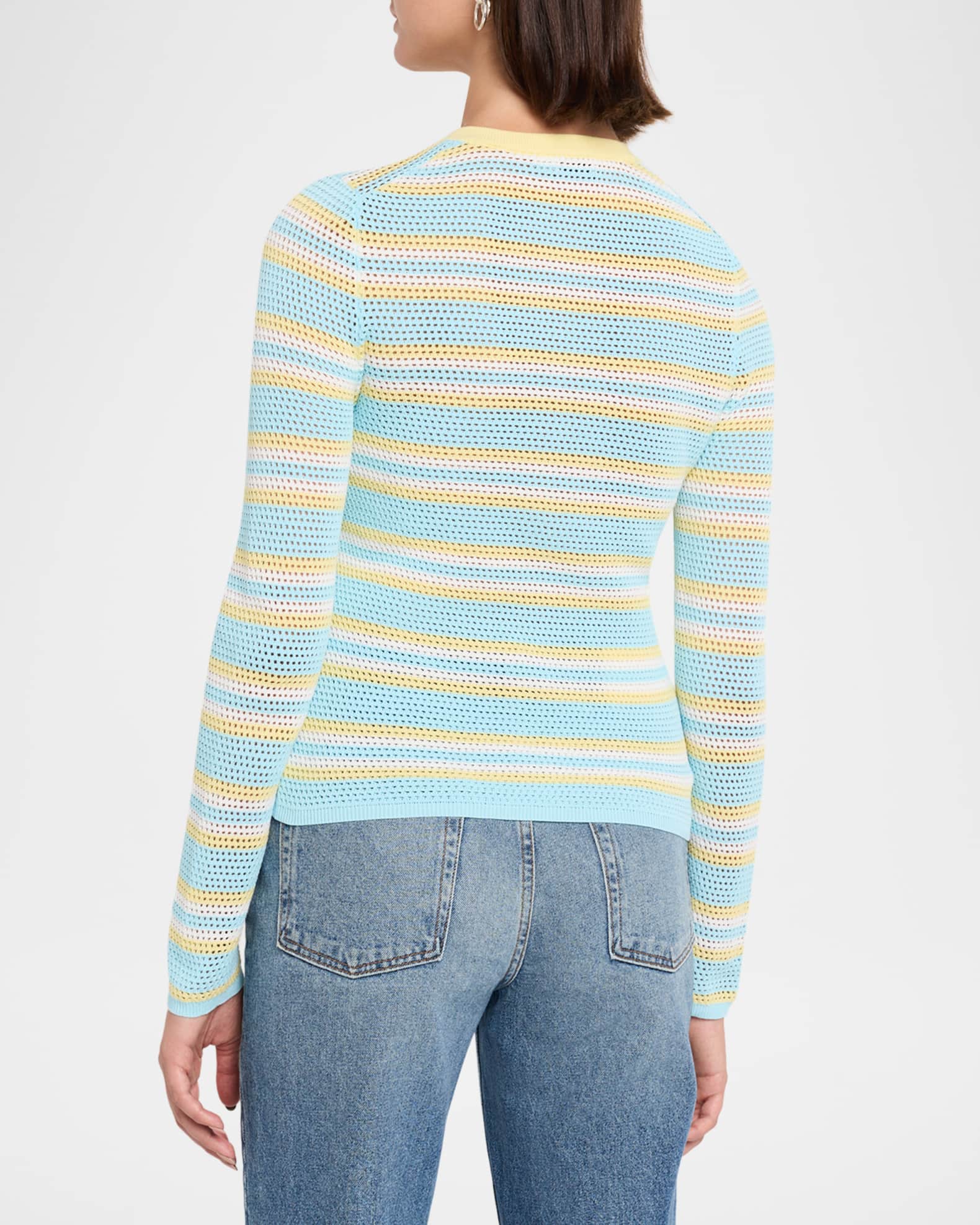 A woman shown from the back wearing a light blue knit sweater with horizontal yellow and white stripes, paired with blue jeans, against a plain white studio background.