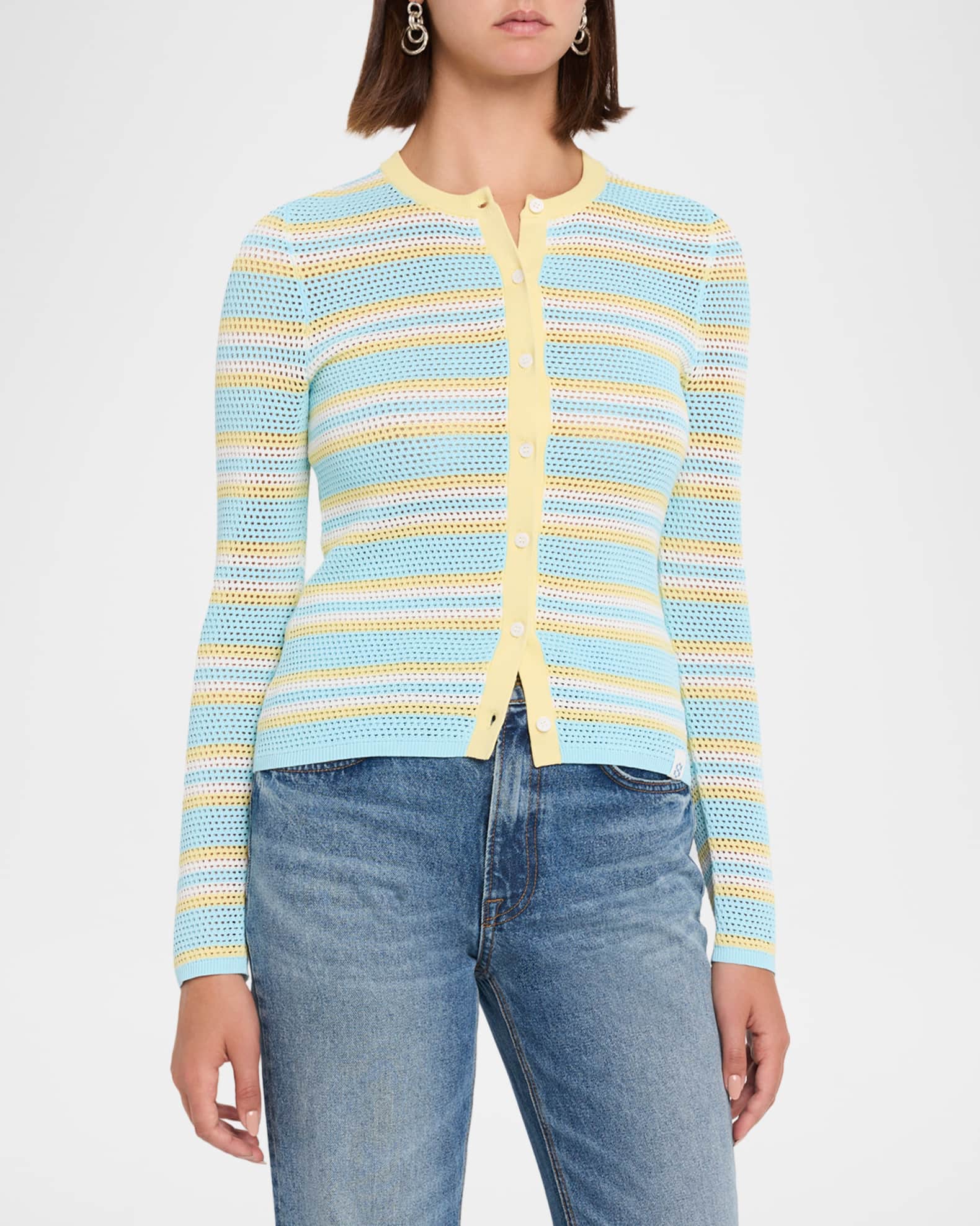 A woman wearing a light blue, yellow, and white striped knit cardigan with blue jeans, shown from the neck down against a plain white background.