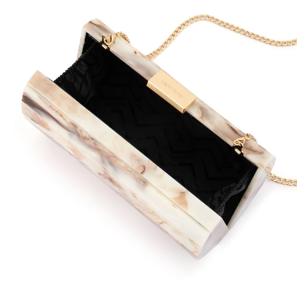 A rectangular clutch bag with a cream and beige marble-patterned outer shell, a black chevron-patterned interior lining, and gold-tone hardware including a chain strap and a metal clasp.