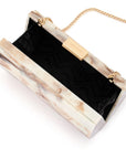 A rectangular clutch bag with a cream and beige marble-patterned outer shell, a black chevron-patterned interior lining, and gold-tone hardware including a chain strap and a metal clasp.