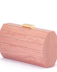 A blush pink wood-grain clutch bag with a small gold metal clasp on top, photographed on a clean white background.