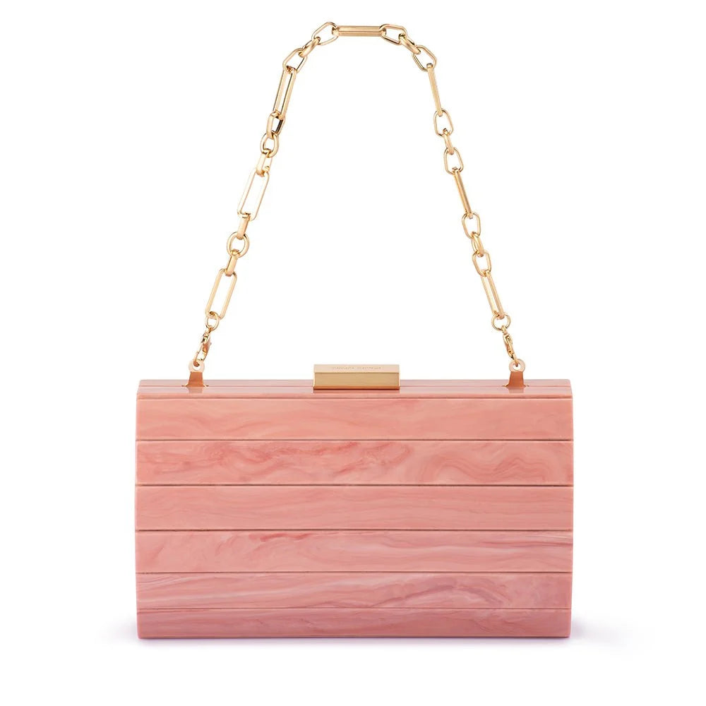 A rectangular wooden clutch bag with horizontal slats in a pink wood grain finish, featuring a gold-tone metal clasp and a gold chain shoulder strap, shown on a plain white background.