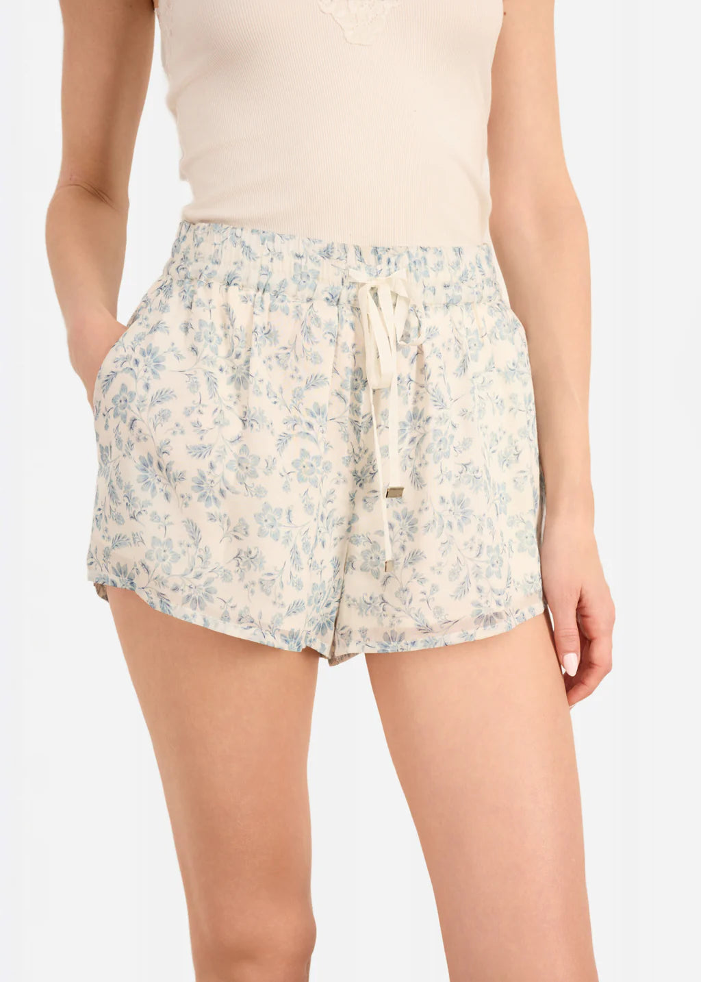 Floral shorts worn by a person on a plain background