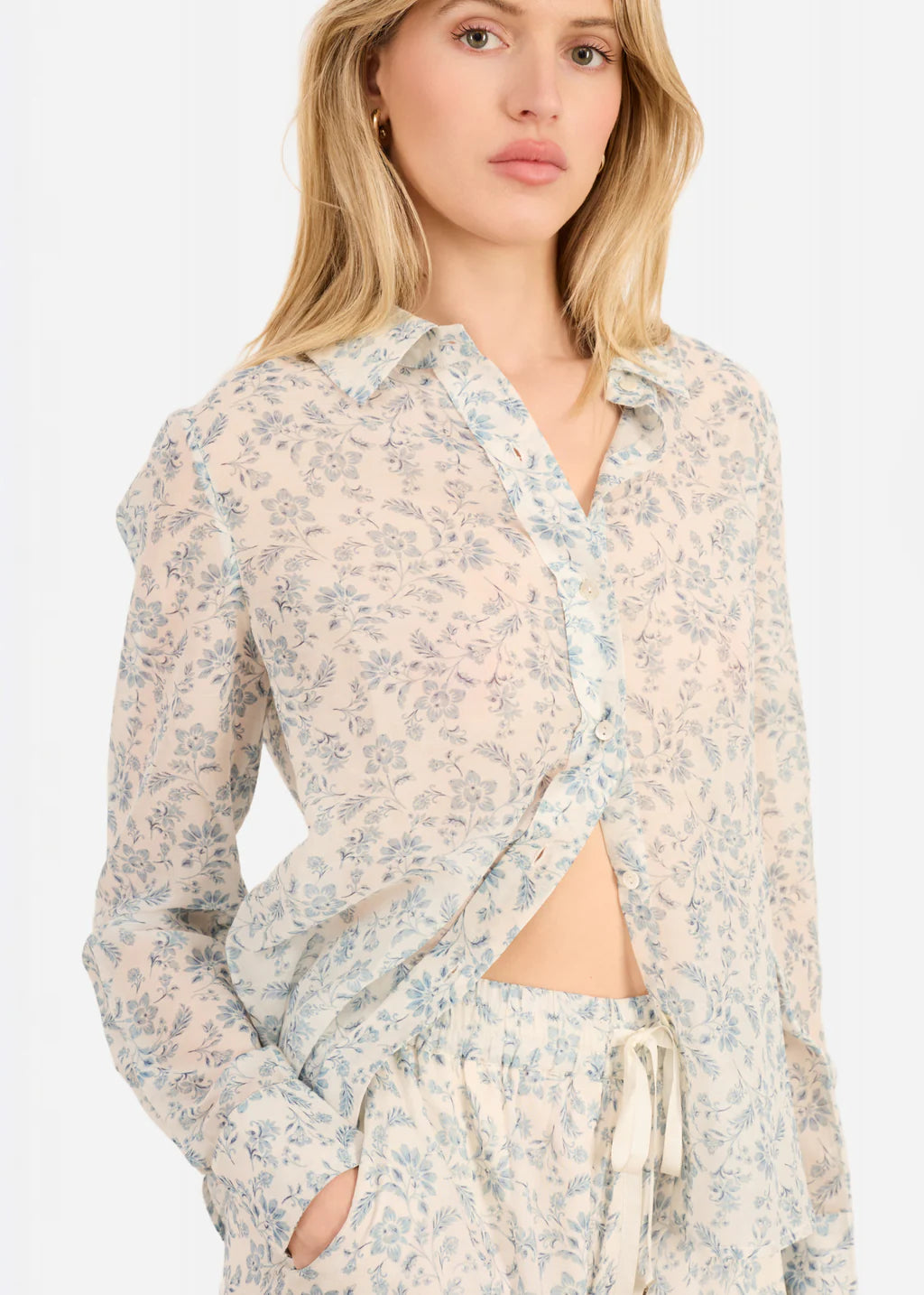 Woman wearing a floral long-sleeve top with a white background