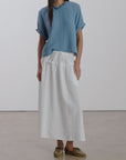 Video of woman in a white skirt and blue top on a white background