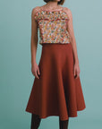 video of a model wearing a floral tank and rust colored skirt