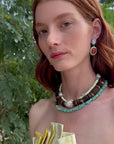 Woman modeling necklace stack and multicolor earrings