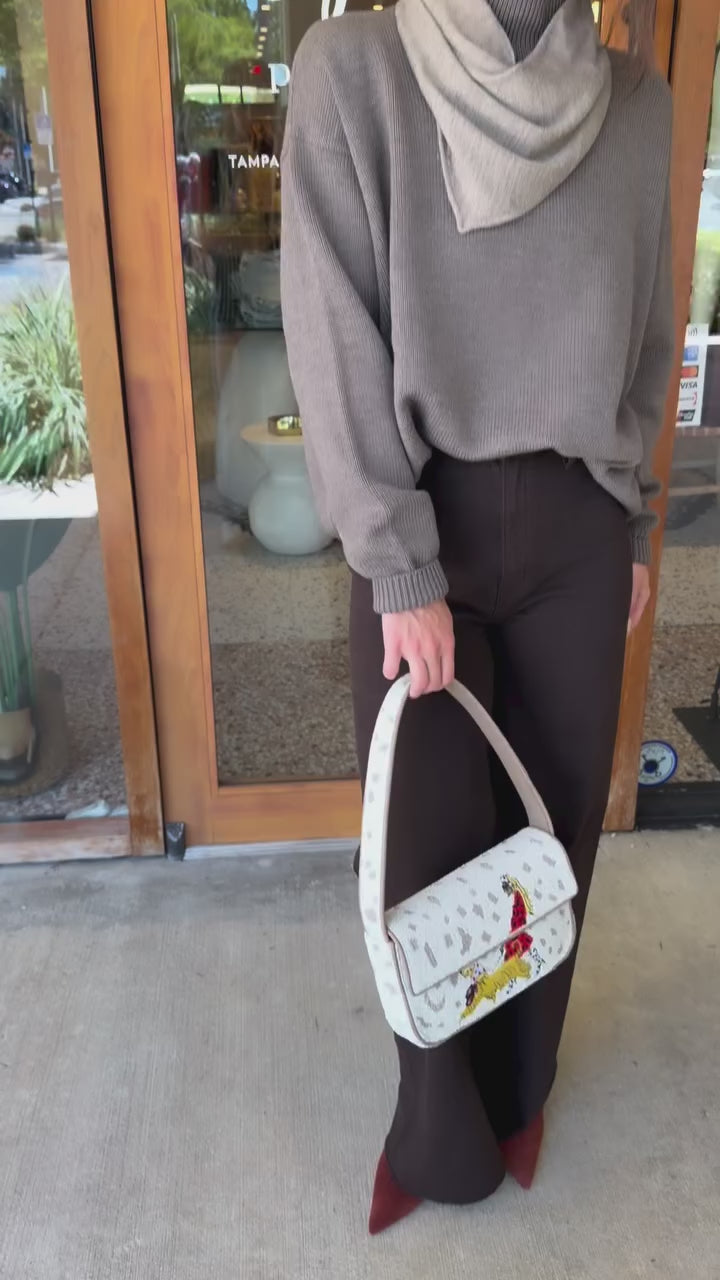 Woman modeling the Winston Sweater, brown jeans and Tommy beaded bag