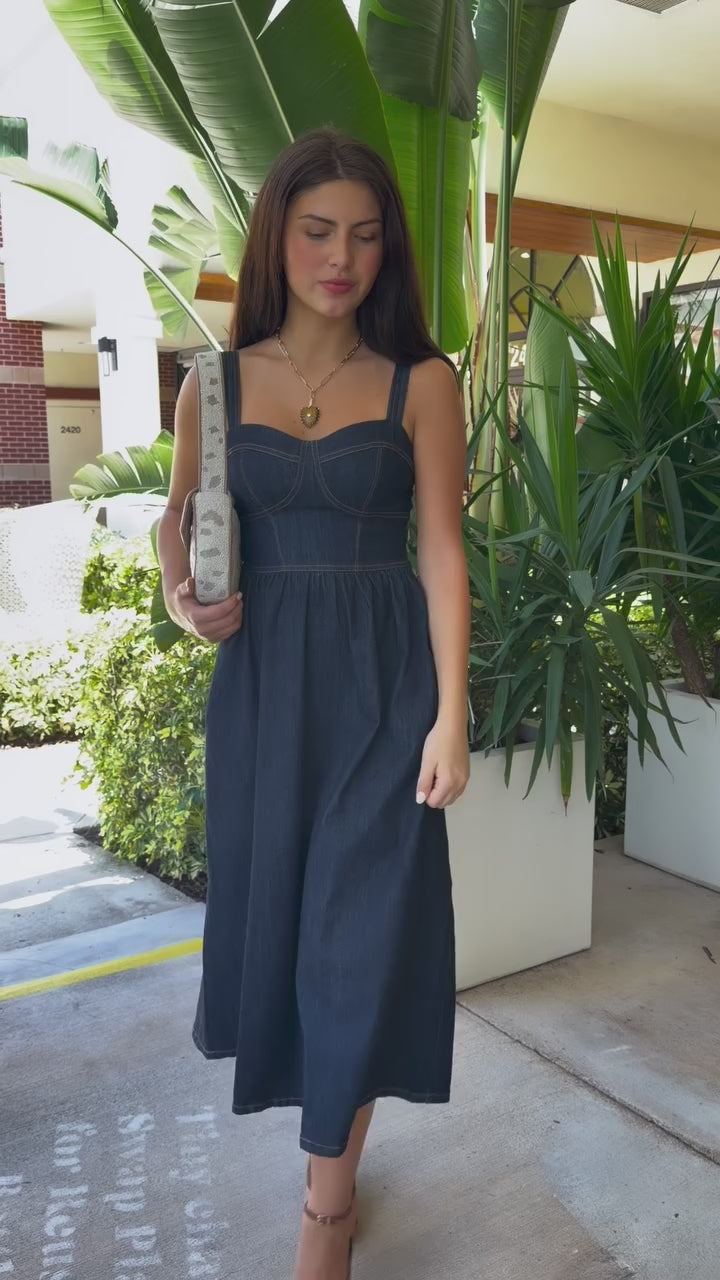 Woman in denim dress with beaded shoulder bag