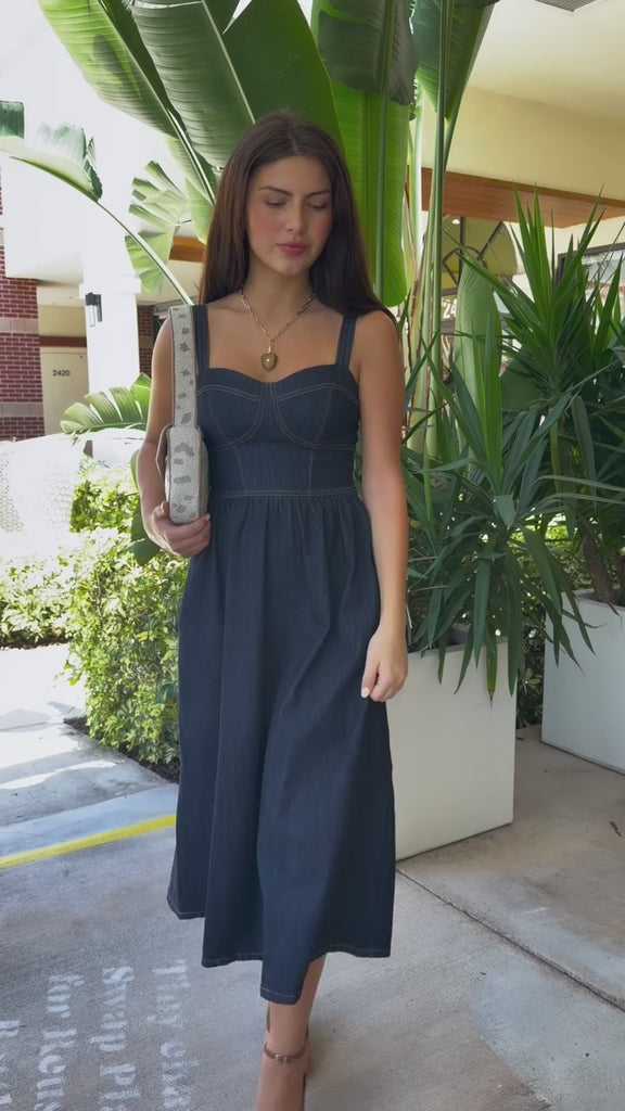 Woman in denim dress with beaded shoulder bag