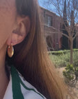video of a woman wearing gold earrings
