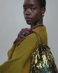 video of a model wearing a blue glass ring and fringe gold bag