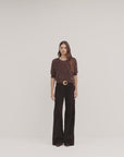 a video of a model wearing a brown fuzzy cropped sweater and dark brown wide-leg pants, set against a plain off-white background.