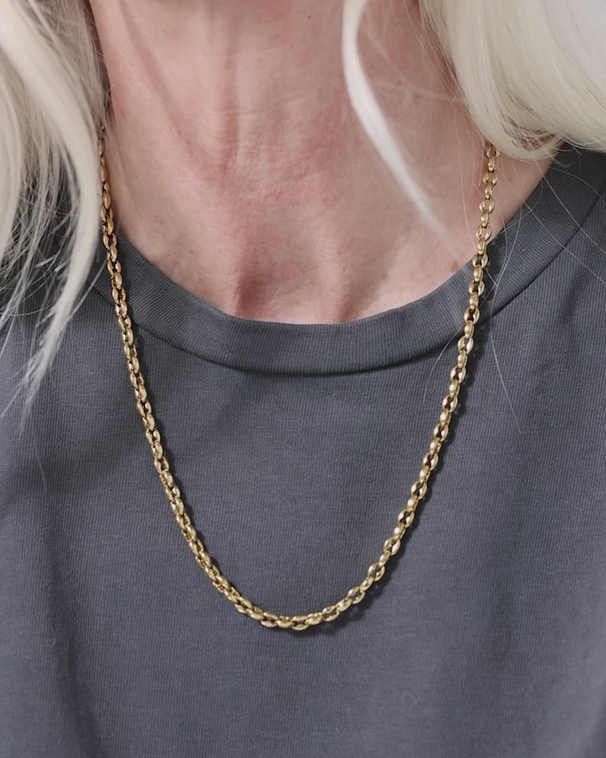 video of woman wearing a gold chain necklace white a grey shirt