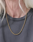 video of woman wearing a gold chain necklace white a grey shirt