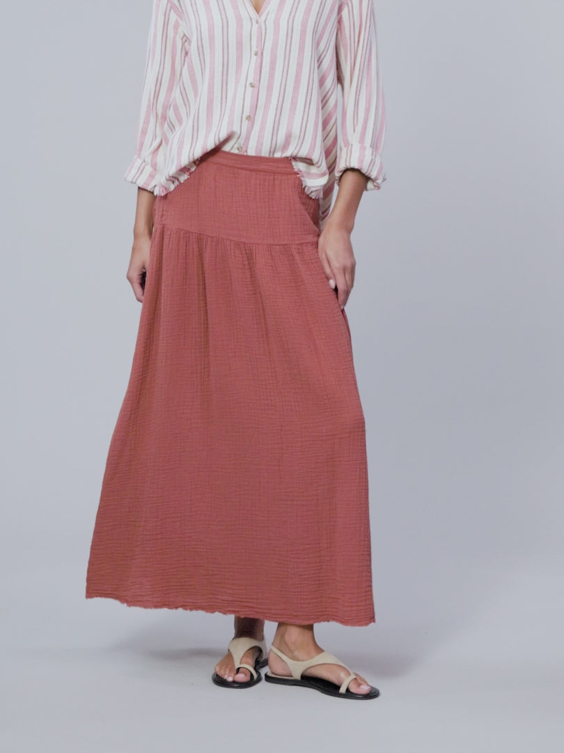 video of a model wearing a striped button up shirt and rust colored skirt