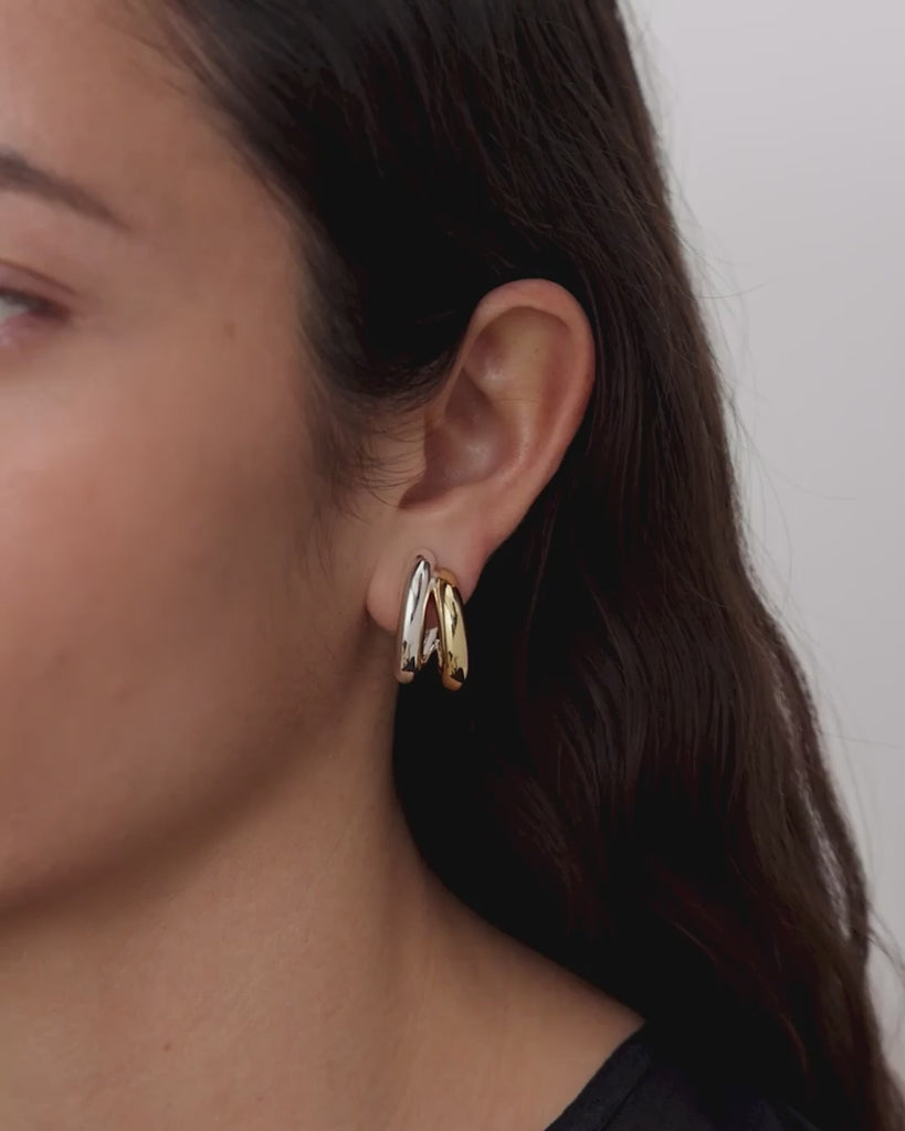 video of woman wearing two-tone hoop earrings