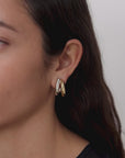 video of woman wearing two-tone hoop earrings