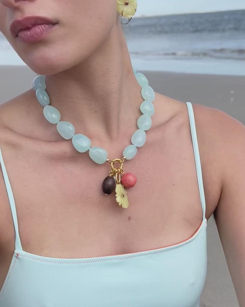 model wearing a blue beaded necklace on the beach