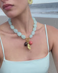 model wearing a blue beaded necklace on the beach