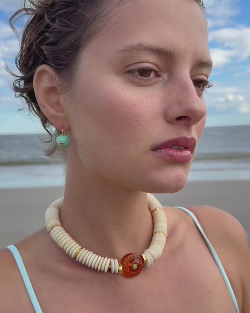 model wearing a beaded necklace on the beach