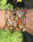 video of gold-tone chain link bracelets with rectangular enamel inlays and a sparkling crystal-encrusted clasp, shown on a plain white background.