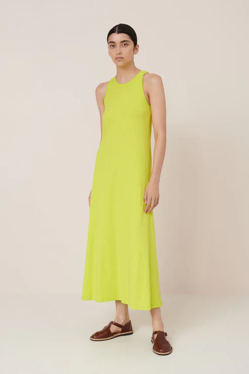 Woman wearing a bright yellow dress against a plain background