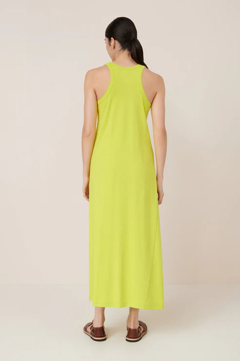 Woman wearing a bright yellow dress on a plain background, back