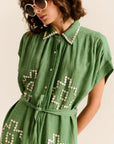 Woman wearing a green dress with star patterns on a beige background