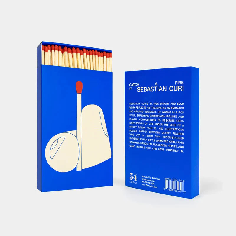 Blue matchbox with a graphic of a match and a book titled 'Catch a Fire by Sebastian Curi'.