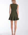 A woman shown from the back wearing a sleeveless olive green mini dress with a defined waist and flared skirt, paired with beige lace-up high heels, against a plain white studio background.