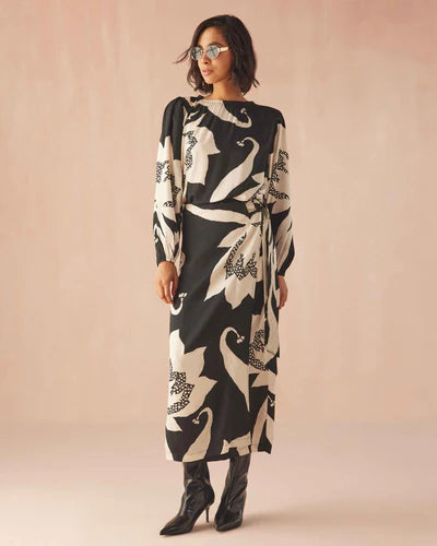 Woman wearing a black and white patterned dress on a beige background