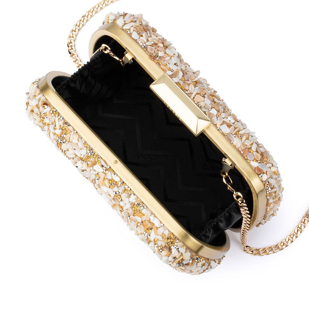 clutch with crushed shells and gold details on a white background, open from top with black inside