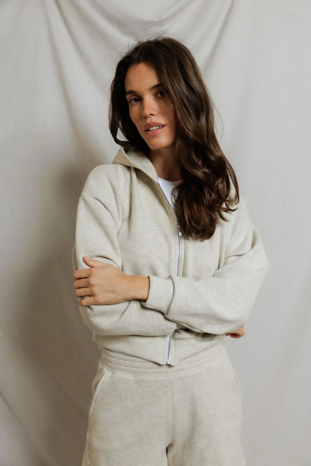 model wearing a zip up hoodie and lounge shorts in the color oatmeal