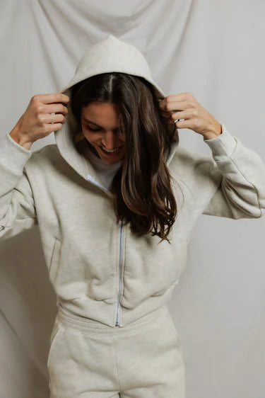 model wearing a zip up hoodie and lounge shorts in the color oatmeal