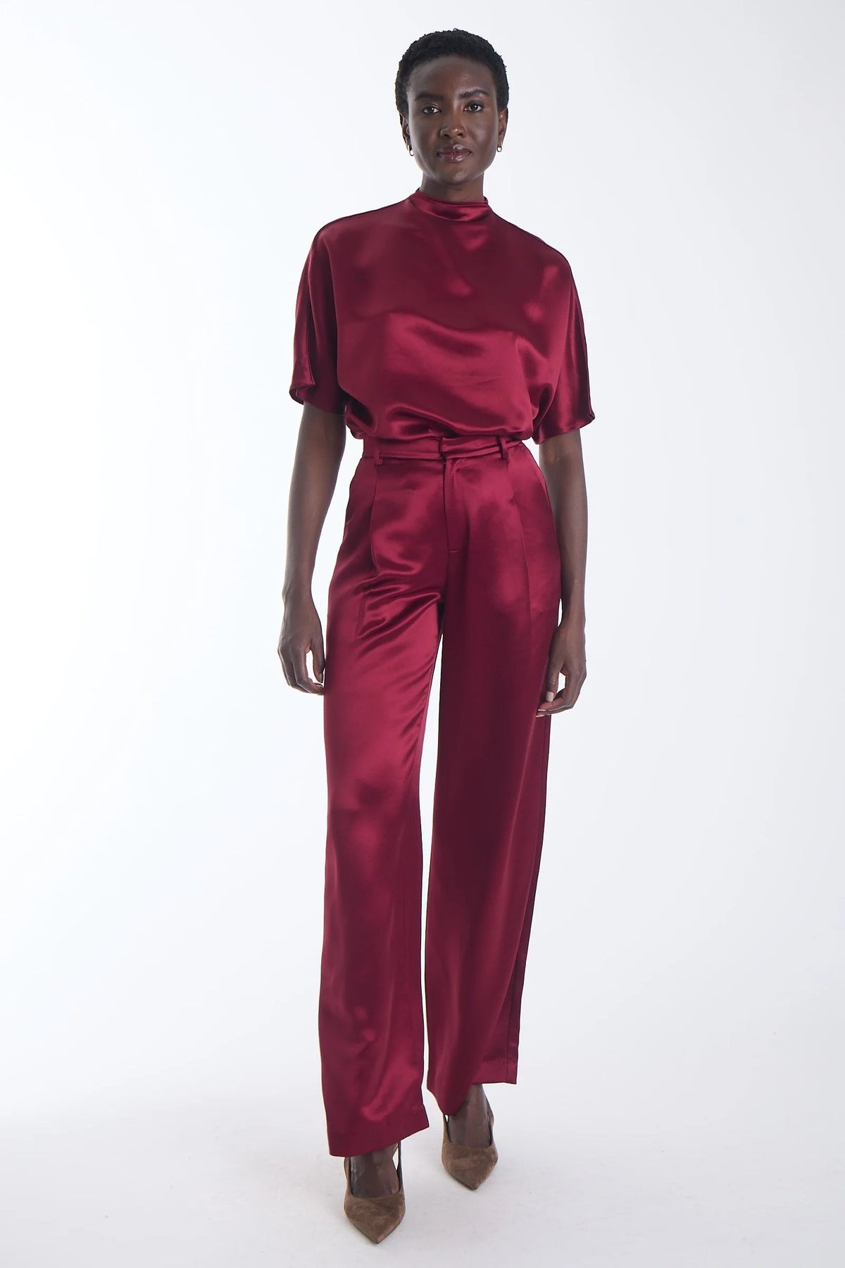 model wearing a wine colored silk short sleeve top and matching pant on a white background 