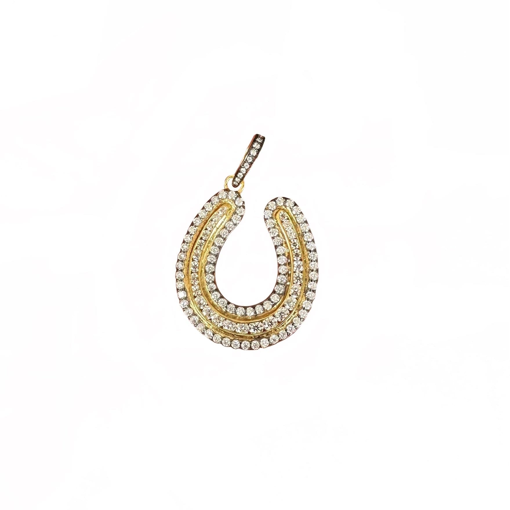 A gold horseshoe-shaped pendant adorned with rows of clear pavé gemstones, shown on a plain white background.