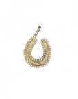 A gold horseshoe-shaped pendant adorned with rows of clear pavé gemstones, shown on a plain white background.