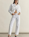 Woman wearing a white denim outfit with a beige background