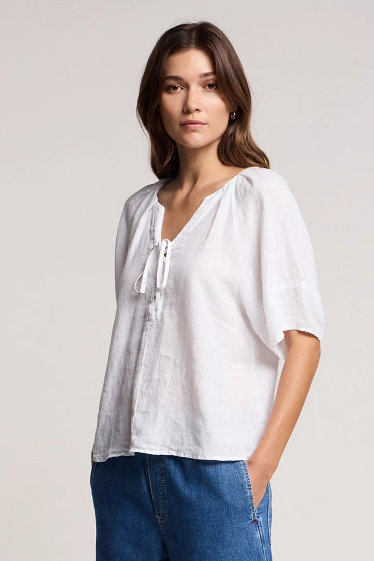 Woman wearing a white blouse with a plain background