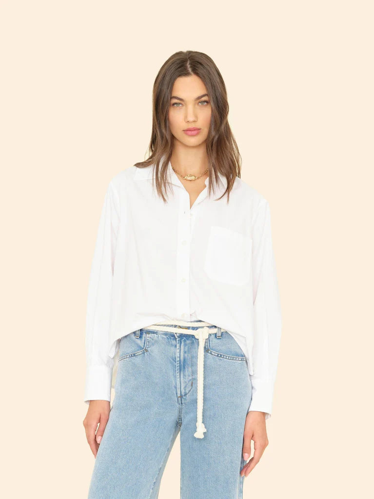 Woman wearing White Monroe Shirt and light blue jeans on a beige background